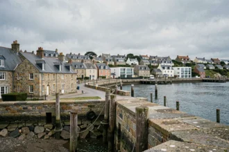 Vue panoramique d'un port breton avec maisons en pierre et immeubles résidentiels modernes, illustrant le marché immobilier en Bretagne