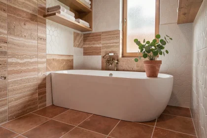 Salle de bains rénovée avec carrelage zellige blanc mat, sol en terre cuite et baignoire céramique autoportante aux accents laiton